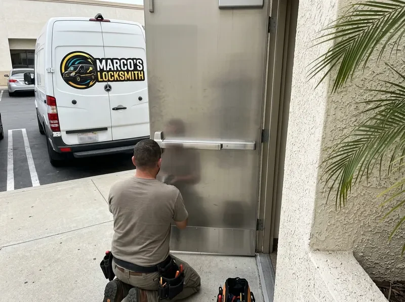 Panic bar and door closer being serviced on a commercial exit door