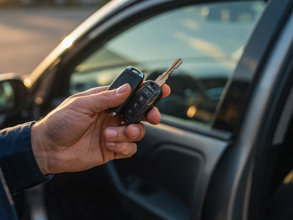 Duplicate smart key fob and freshly cut key held at a customer vehicle after programming on site